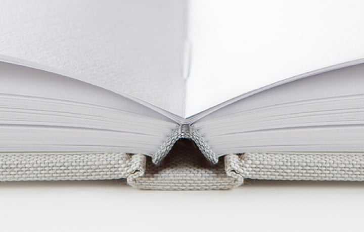 Close up of MILK Photo Book showing stitched binding and paper pages